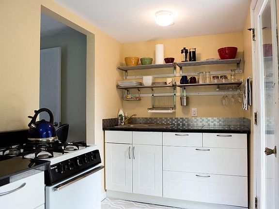 Kitchen with gas stove, full-size fridge, door to deck.