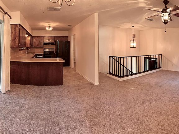 large living room/kitchen with a balcony area through the do