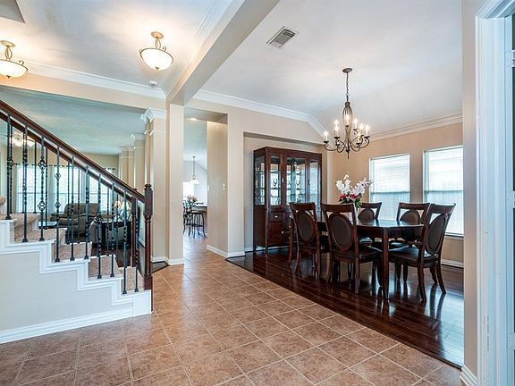 Large tiled entry with gorgeous light fixtures and double crown molding.