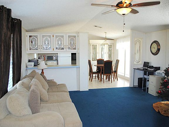 Living room has built-in cabinets with decorative glass inserts, has pass-through to kitchen & is op