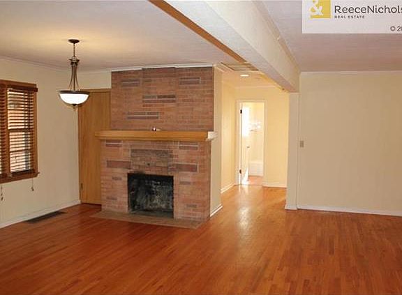 LIVING ROOM HAS A COZY FIREPLACE AND OPEN TO DINING & KITCHEN AREA