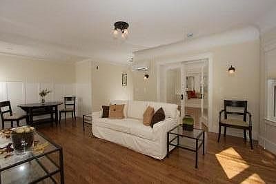Living room with dining alcove and a view to 2nd bedroom with window seat. Coved ceilings, wainscoting, hardwood floors, high-end, historically appropriate lighting and hardware.
