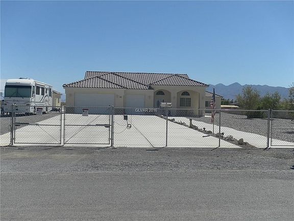 Exterior front from the street, property is completely chain linked fenced.