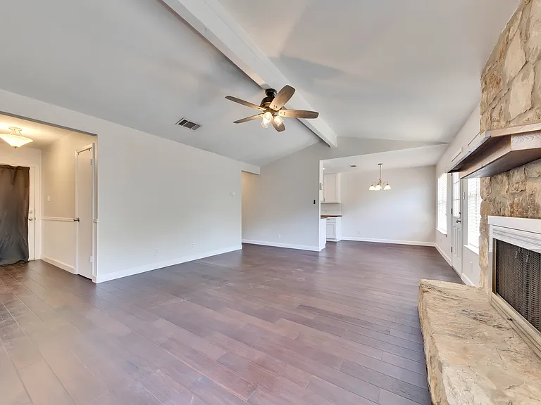 Spacious Living Room: Relax and unwind in the expansive living room complete with vaulted ceilings and a cozy fireplace, creating a warm and inviting atmosphere.