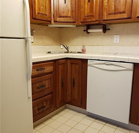 Functional kitchen with ceramic flooring and plenty of storage