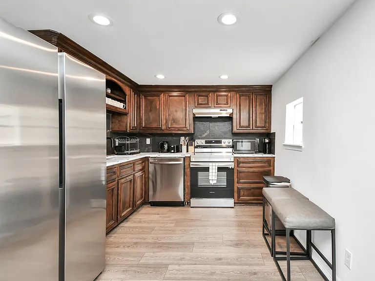 Kitchen with all stainless steel appliances included. Refrigerator, dishwasher, electric stove with oven, and a microwave.