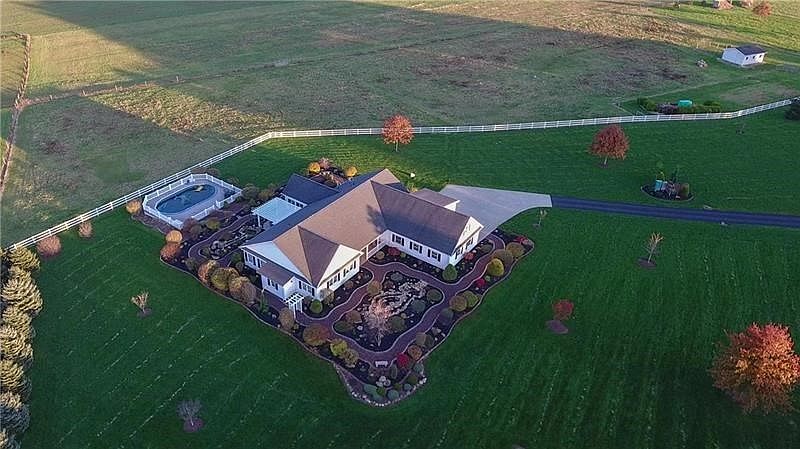 View of the home showing front entrance and lush landscaping.  Note the spectacular view of the neighboring valleys.