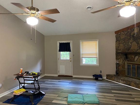 Looking from front door to the back door. Wood burning fireplace on the right. Best for ambiance rather than heating the house.
Backdoor leads out to small patio and huge yard. Hallway to bedrooms and bathrooms on the right and kitchen/dining to left