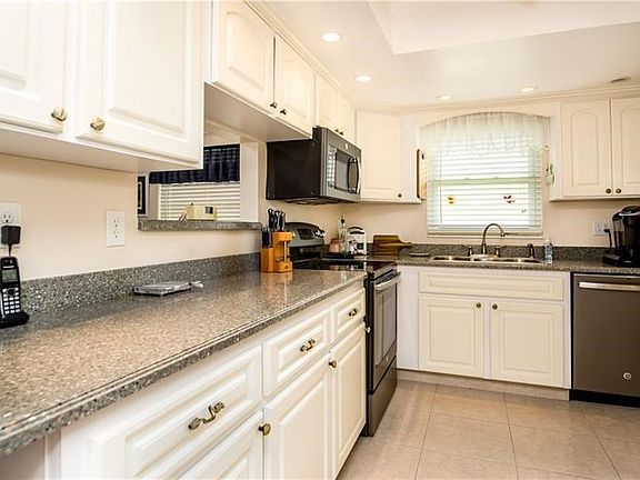 Kitchen updates include Corian counters, Raised panel white cabinetry, Recessed lighting.
