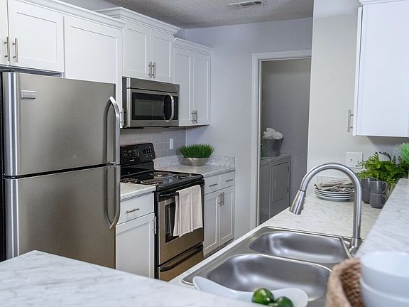 Carrara marble-inspired countertops grace the breakfast bar, creating a timeless and luxurious atmosphere in this expansive kitchen. Ample countertop space and storage ensure both style and functionality.