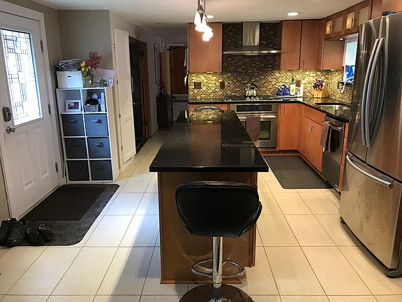 Renovated kitchen with ample storage, large refrigerator, dishwasher, & granite countertop. Stocked with dishes, cookware & storage containers. Chairs not there anymore.