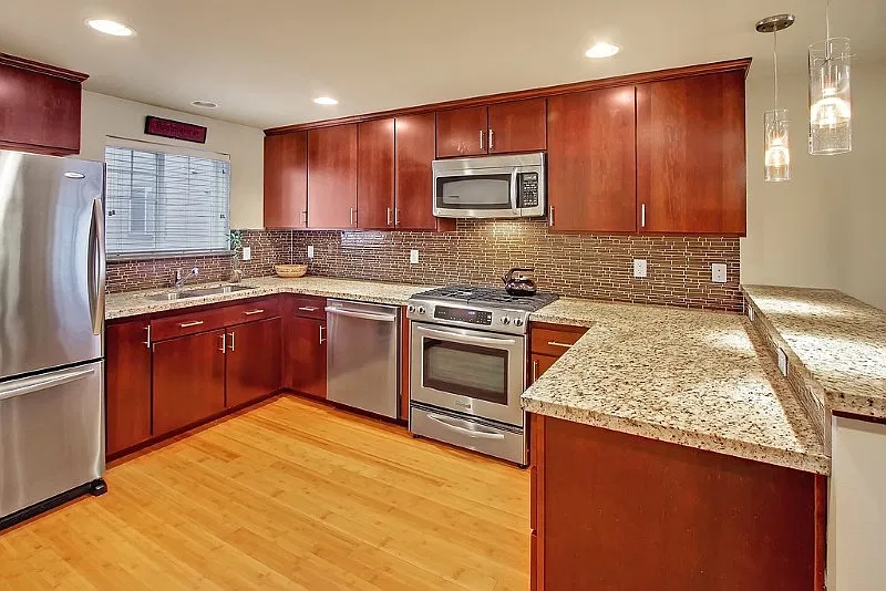Large kitchen with granite counters, stainless appliances, bamboo hardwood floors and tile backsplash. Breakfast bar for casual dining or morning coffee.