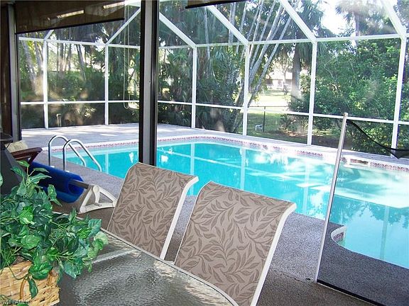 View of pool from center section of huge covered lanai.  You can also see an uncovered section of lanai in center left of photo 