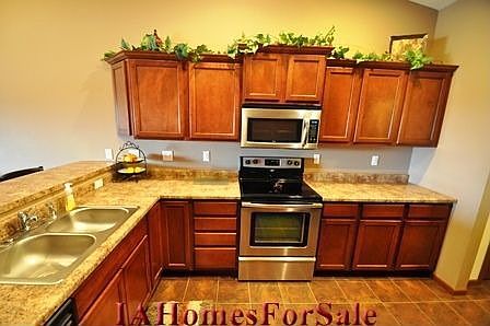 Kitchen with many upgrades - tile floor, stainless steel appliances, and raised breakfast bar.