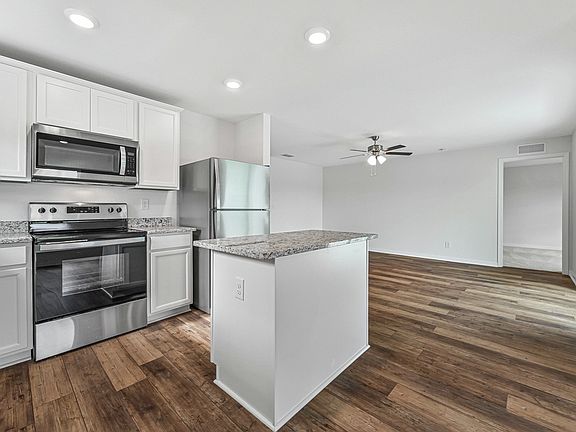 The kitchen also has beautiful white cabinets and granite countertops
