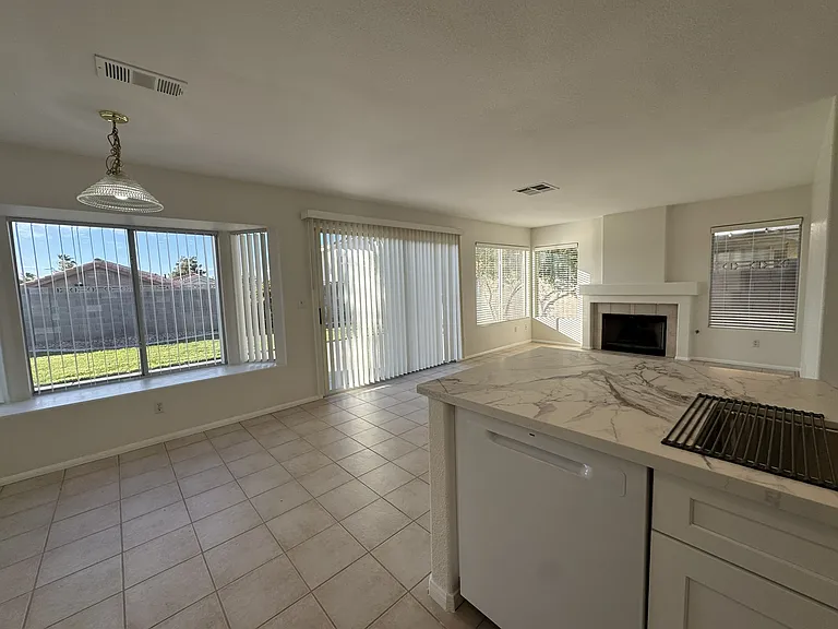 An inviting open-concept living area boasts a modern fireplace and a view of the private yard.