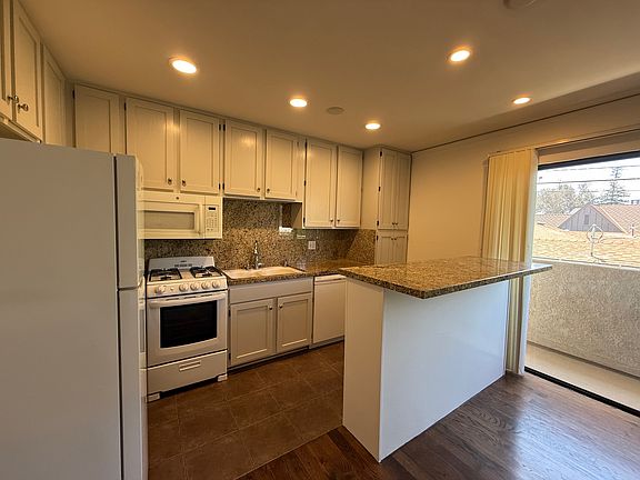 Kitchen with stove, dishwasher, microwave and refrigerator-Granite counter tops with eating bar
