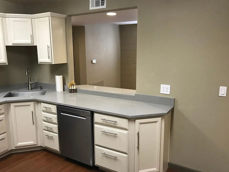View from kitchen into entry room. Note dishwasher.