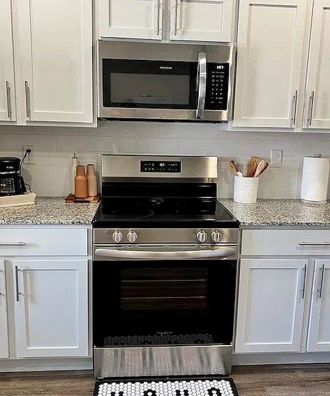 Stainless steel smooth-top electric stove with built-in microwave.