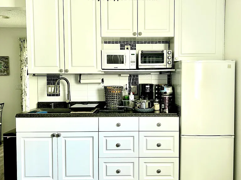 Microwave, large toaster oven, coffee maker, induction cooktop with compatible pots and pans, utensils and silverware all included. Huge sink with disposal unit.