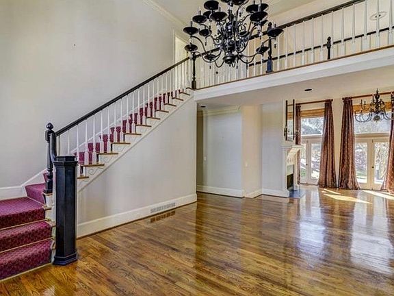 Front stairs to the second floor with two story foyer and living room separated by a catwalk.