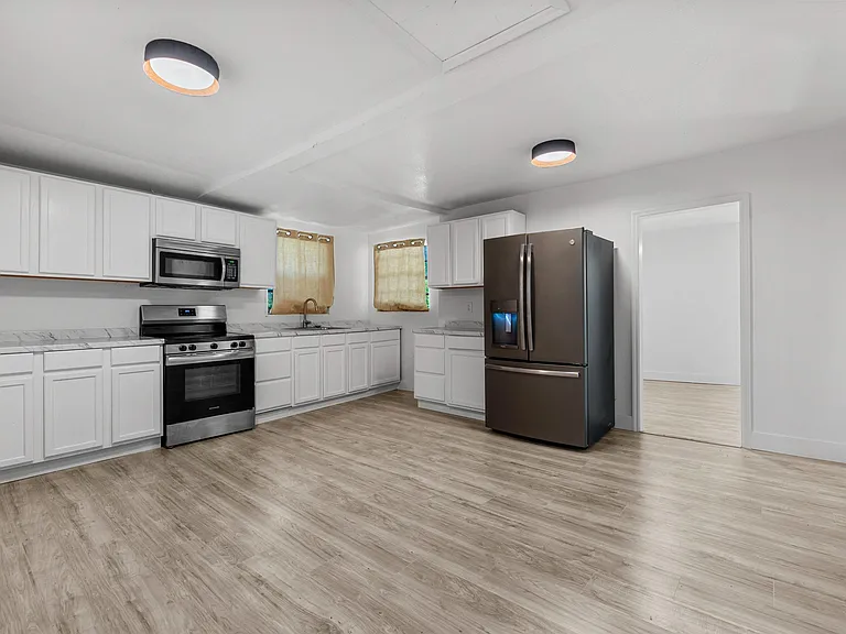 Spacious kitchen with ample white cabinetry, generous counter space, and stainless-steel appliances including a French-door f
