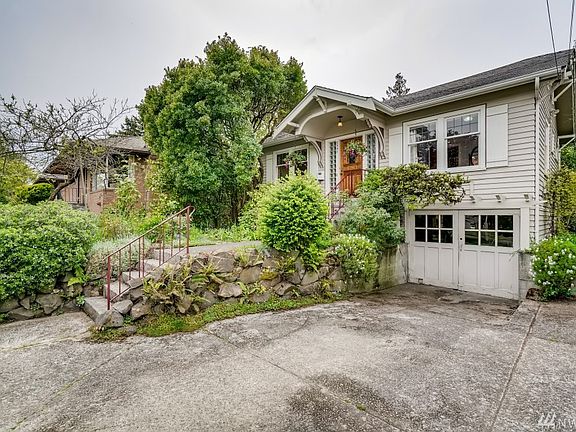 Terraced yard with a producing peach tree and fragrant Daphne in the front