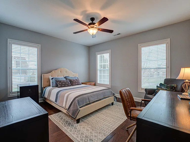 Guest bedroom 1 with queen bed and desk.