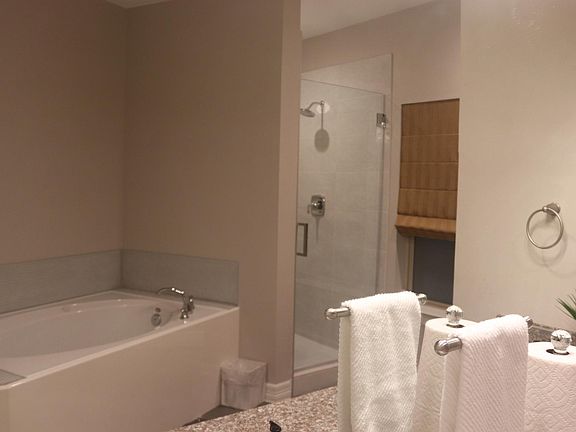 Primary bathroom has a jetted tub, walk-in shower with built-in seat, and blow dryer. Towels are supplied upon request.