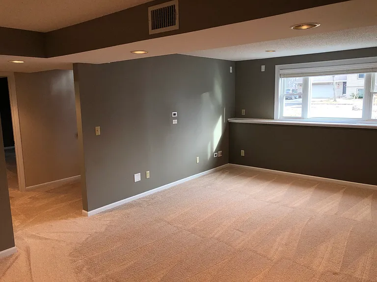 Basement with large lookout picture and sliding window.