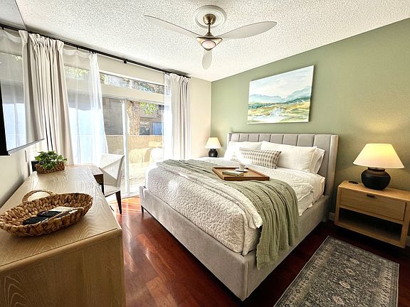 Primary Ensuite with plush king bed and luxe furnishings. Features a mirrored walk-in closet plus extra mirrored closet, 65" Smart TV, and a fully equipped workstation perfect for relaxing, working remotely, or unwinding after a day of exploring.