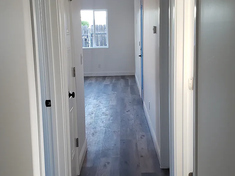 Hallway that leads to laundry room and bedrooms. This aspect is facing front of the house. Smoke alarms in hallway and every room.