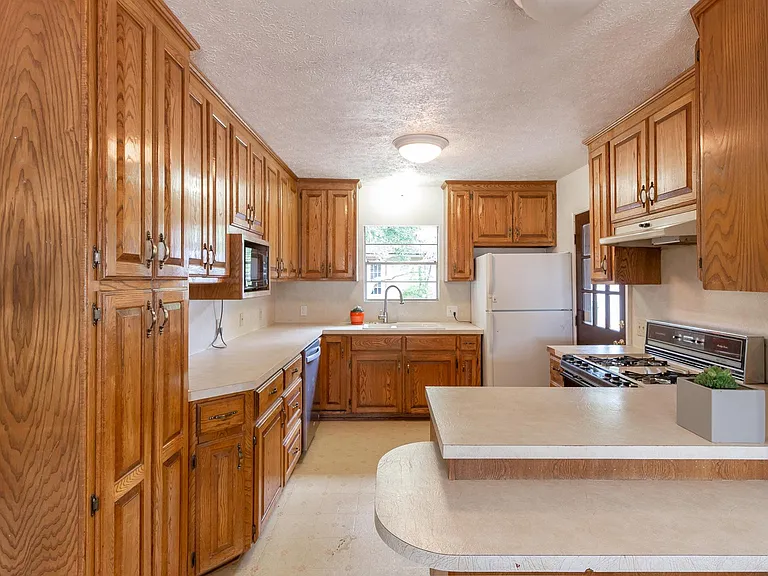 opposite view of kitchen, door to carport, gas stove