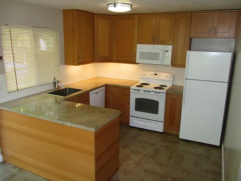 Remodeled kitchen with a generous amount of storage space, abundance of countertop space.. Undercounter cabinet lights, dishwasher, microwave and refrigerator provided.