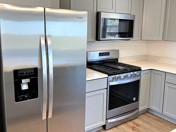 Kitchen and stainless steel appliances and gray cabinets in a DRB Homes Whitehall II plan in the Che