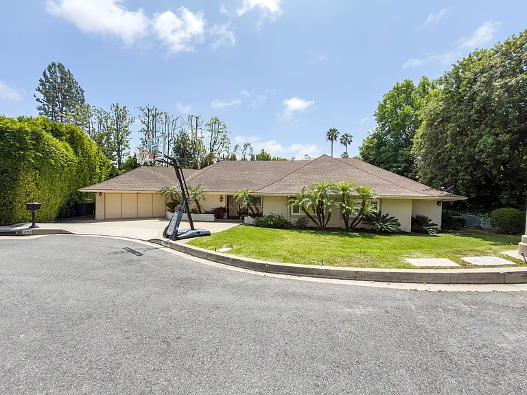 Attached garage and a lush front lawn frame this classic ranch-style Beverly Hills luxury rental at 1094 Garden Lane, a 90210 home for rent.