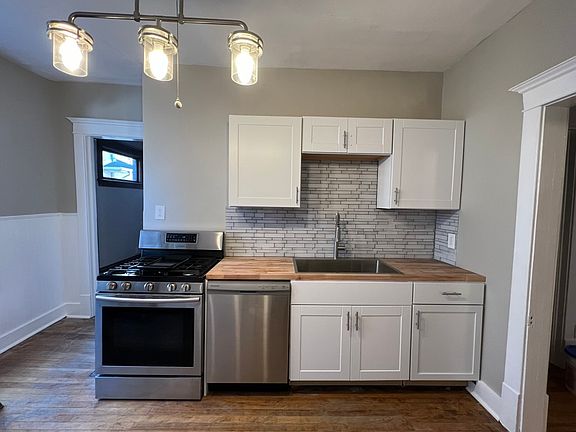 Off the Dining Room is the remodeled Kitchen. New cabinets, appliances, lighting, glass backsplash, butcher block counters, stainless sink, gas stove.