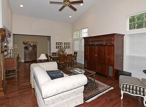 The expanded greatroom features a vaulted ceiling with canned lighting, wood floor, gas fireplace & lots of natural light.