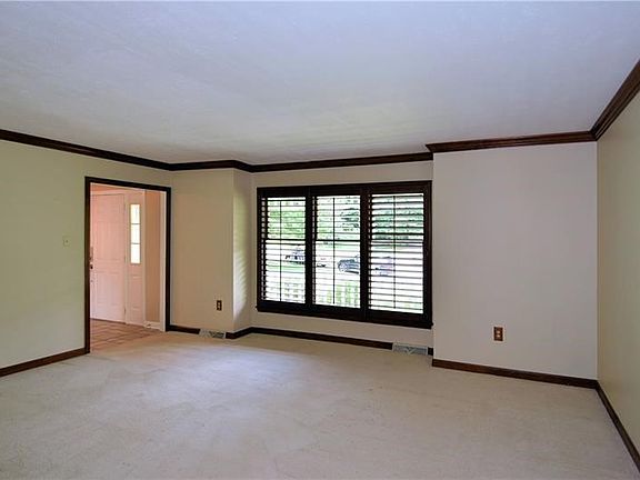 Large living room with brand new carpeting and wood plantation shutters.