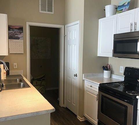 Fully stocked kitchen with electric range, refrigerator with ice maker, disposal, dishwasher, pantry and separate laundry room with hanging storage and full size side by side washer and dryer.