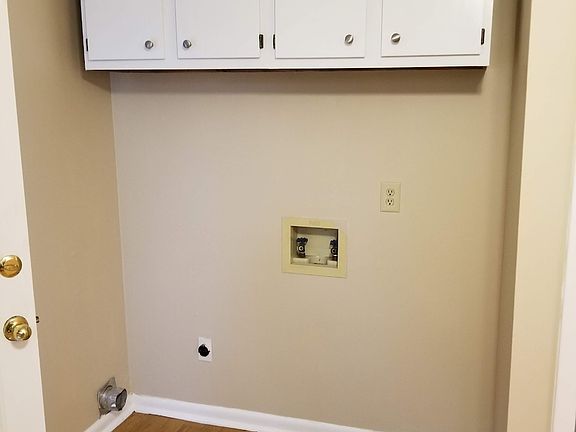 Laundry with washer & dryer hookups with storage area above.