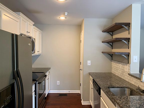 kitchen with SS appliances, white cabinets, granite counter tops, marble back splash.