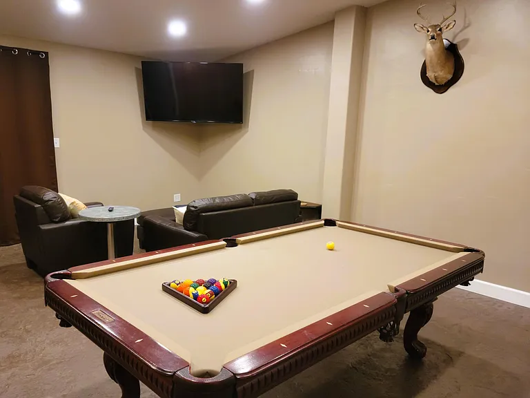 Game room with 65-inch TV, pool/ping-pong table.