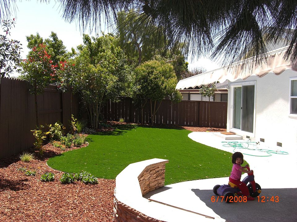The landscaped back yard with artificial grass.