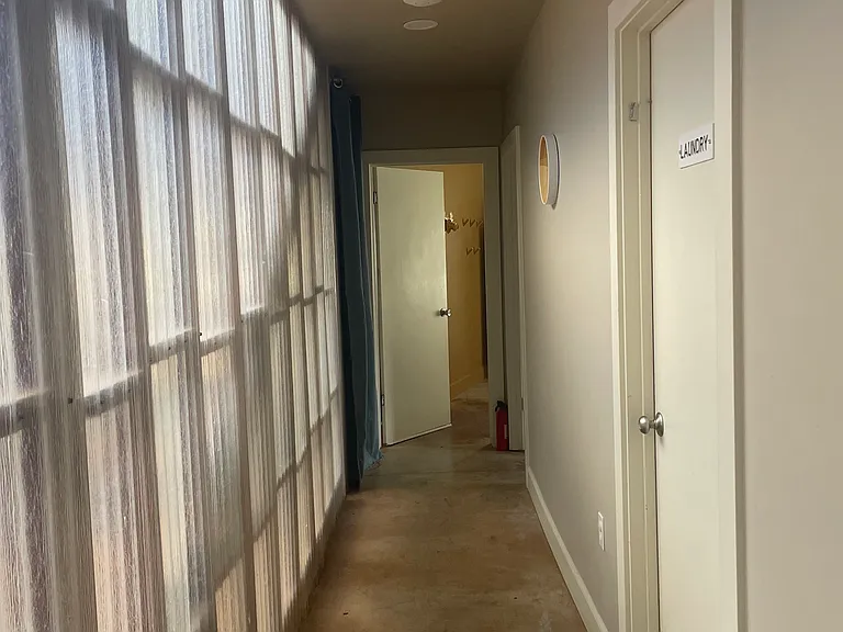 Hallway to laundry room, bathroom, downstairs bedroom with garden access.