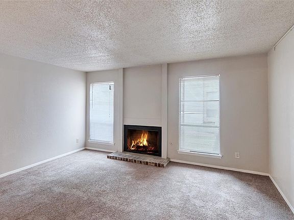 ANOTHER VIEW OF THE LIVING ROOM WITH WOOD BURNING FIREPLACE