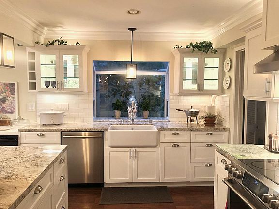 Remodeled kitchen with farm sink and refrigerator with built-in Keurig, drawer microwave, and convection oven.