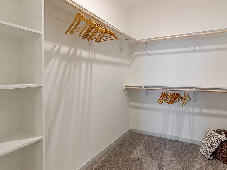 Oversized walk-in closet with built-in shelving and double hanging rods. Oversized walk-in closet with built-in shelving and double hanging rods.