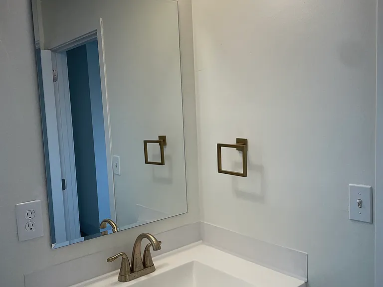 Bathroom-2 custom-designed vanities, Delta gold hardware, large-format tile, and modern rainfall showers
