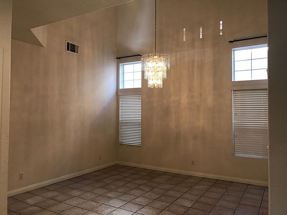 Living area with high 3 large windows and high-vaulted ceilings
